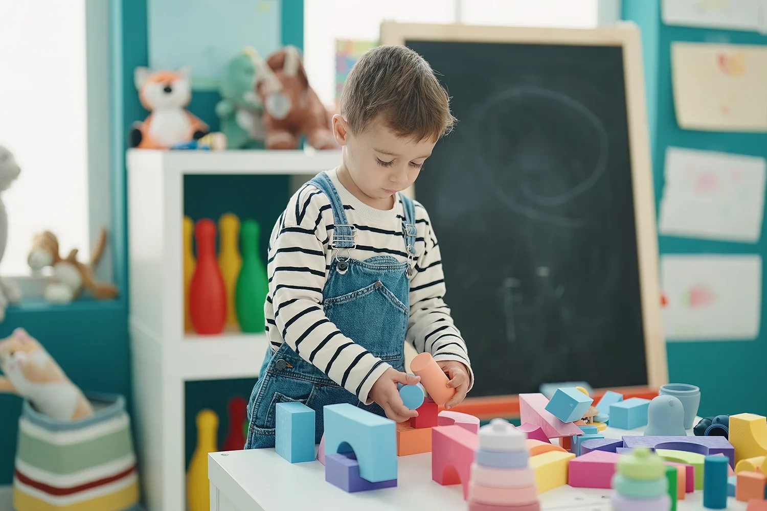 adorable-caucasian-boy-playing-with-construction-blocks-kindergarten copia