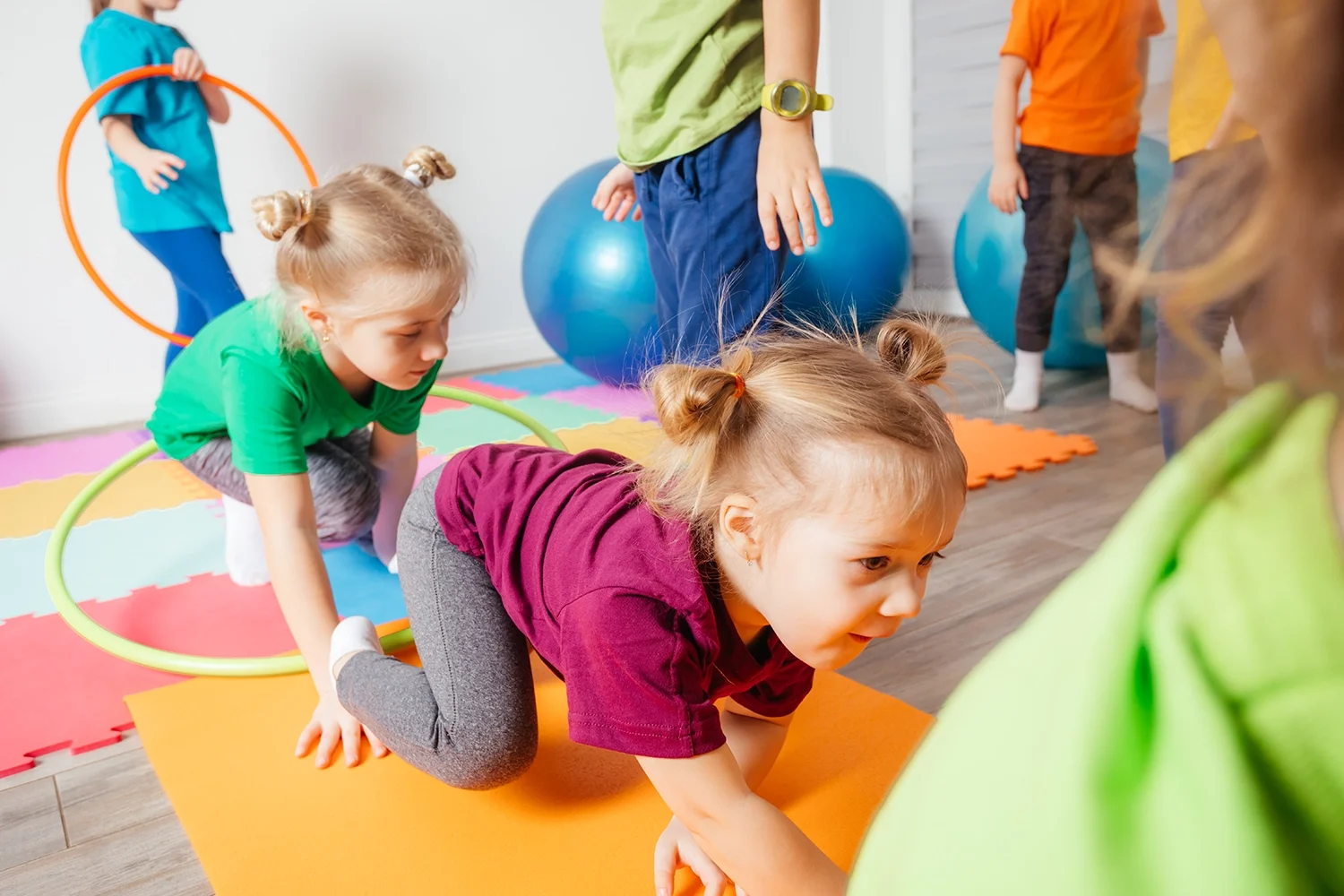 curly-girl-crawling-colorful-floor-through-hula-hoops (1) copia