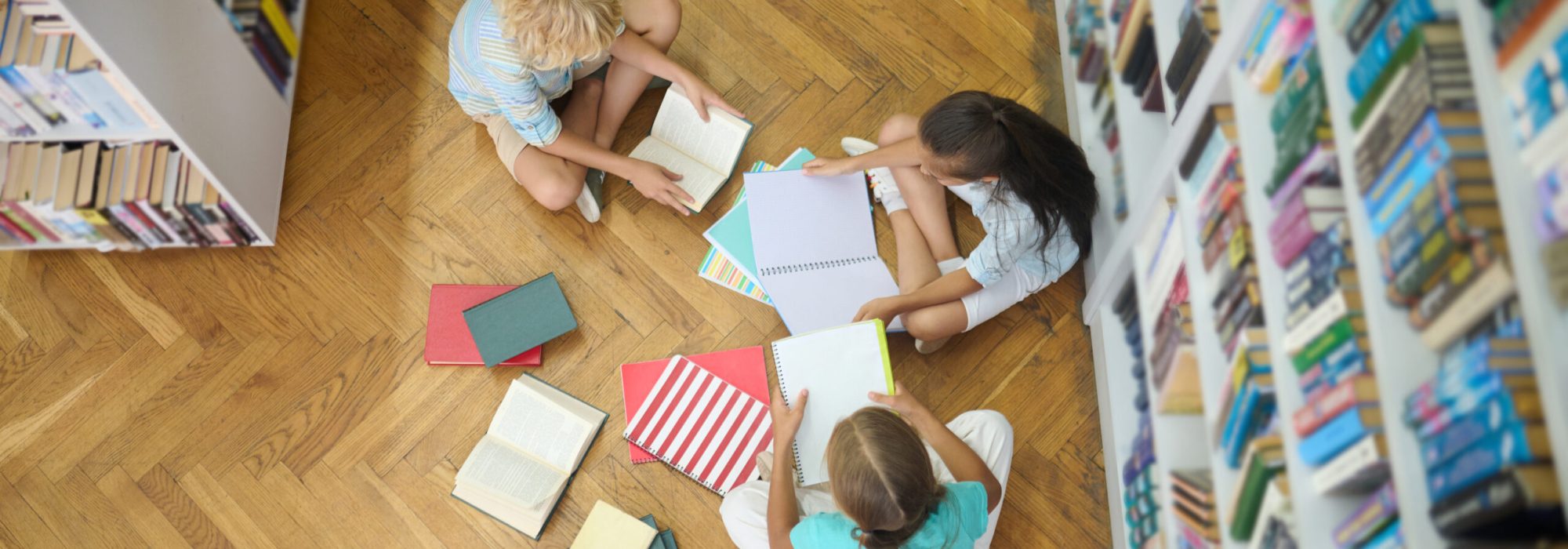 Top view of children studying on floor in library